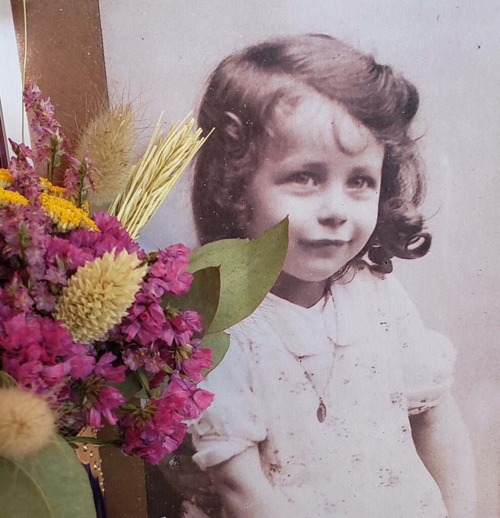 Bouquet de fleurs séchées devant un portrait ancien d’une petite fille